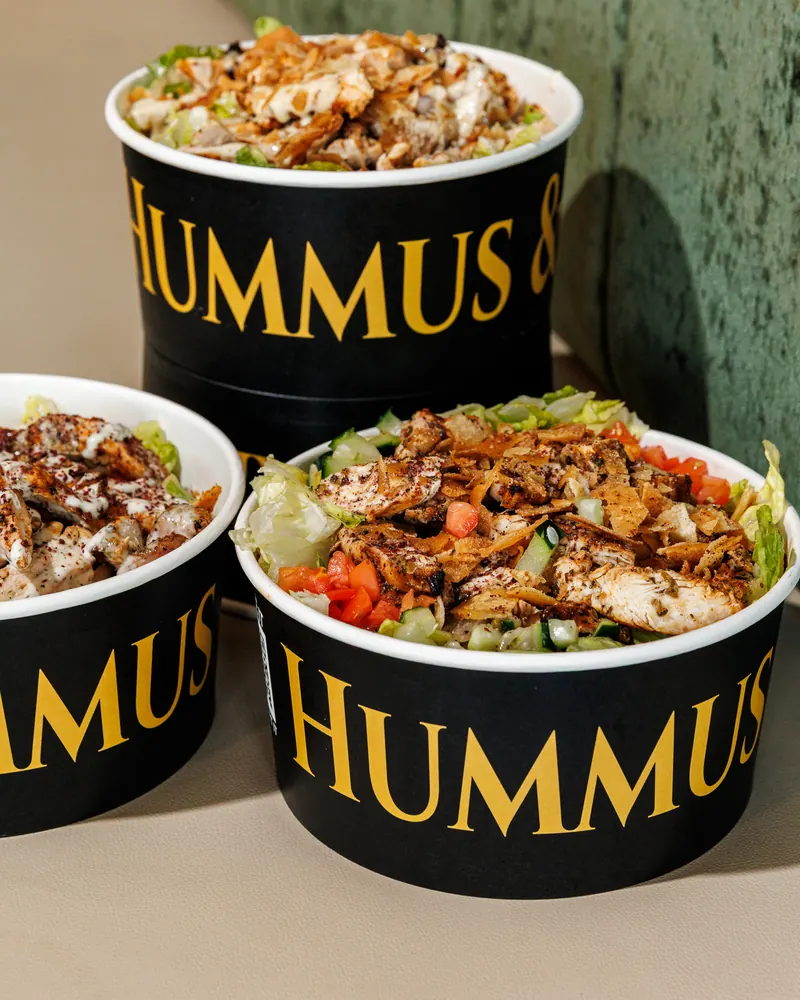 Three grilled chicken bowls stacked on the counter