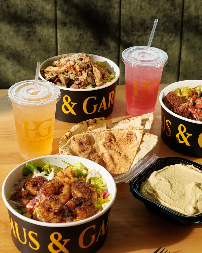 Bowls, pita, hummus and lemonades shared across a table